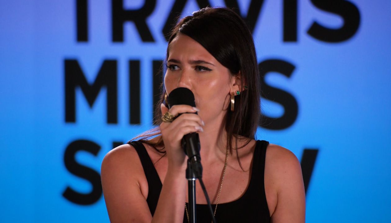 Sienna Spiro singing into a microphone
